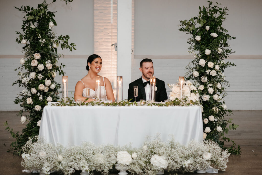 Contemporary bride and groom sitting at their table at the head of their reception in Ohio | J. Lynne Photography