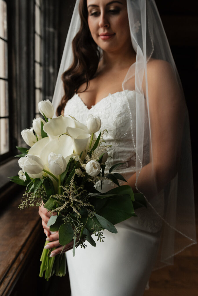 Bride holding her bridal bouquet at her wedding at the Tudor Arms Hotel | J. Lynne Photography