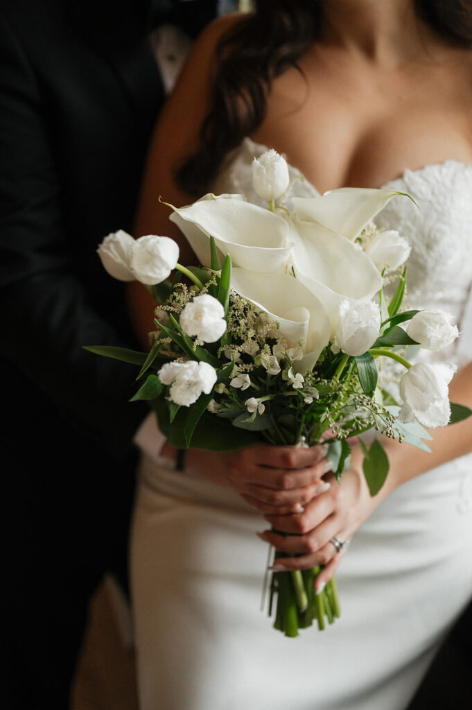 Close up of groom and bride holding the bouquet at historic hotel | J. Lynne Photography