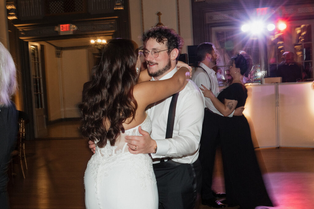 Bride and groom dancing at their wedding reception with friends and family | J. Lynne Photography